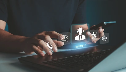 A person using a laptop and a smartphone, with a visual overlay of support icons