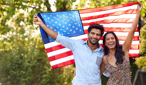 Couple holding the American flag after their green card approval
