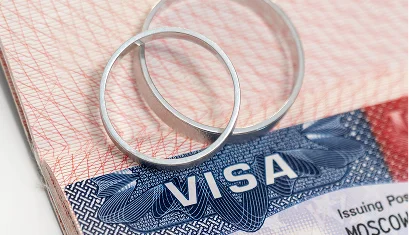 Wedding rings resting on a United States visa